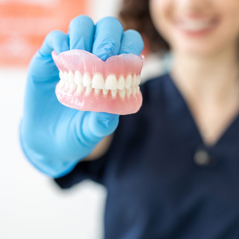 dentist holding dentures
