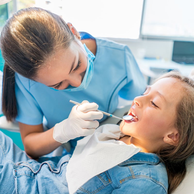 dentist looking in kids mouth