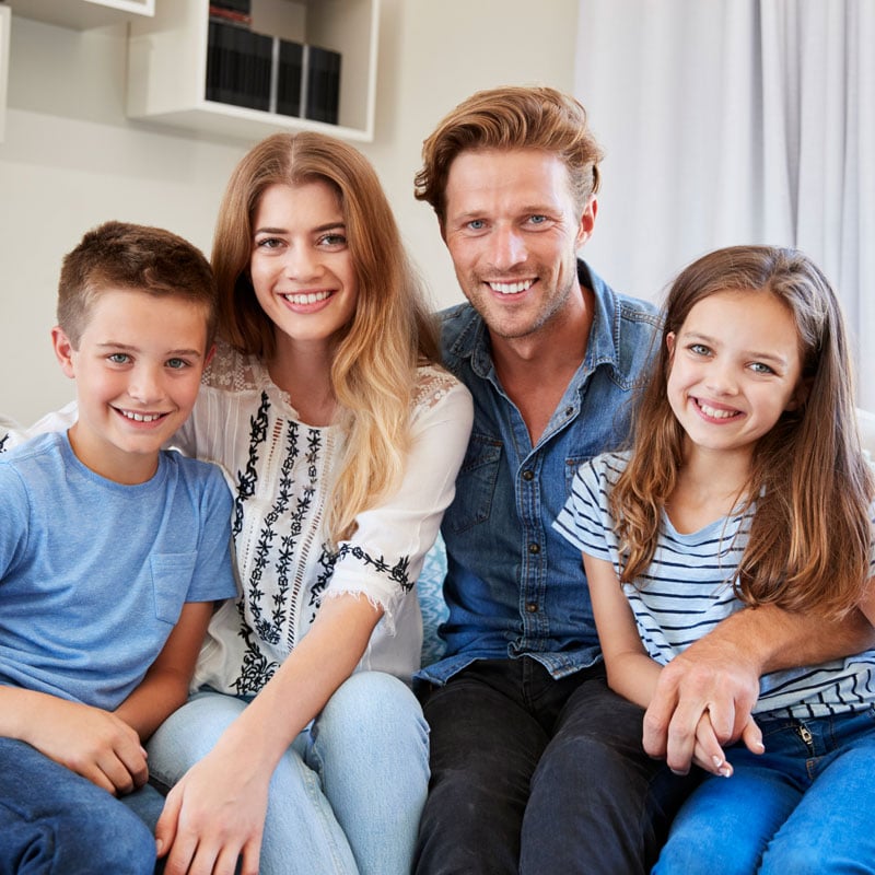 family sitting on couch smiling
